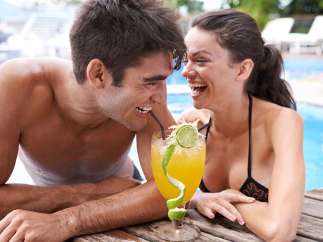 couple drinking by pool